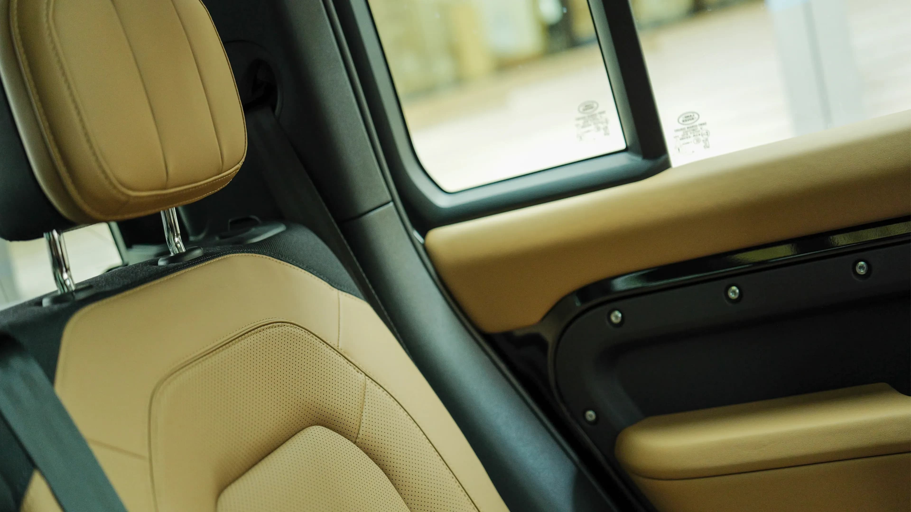 Land Rover Defender V8 mieten in München – Bequeme Ledersitze in edlem Beige im luxuriösen Innenraum des Premium-Geländewagens von Mosaik Motors.