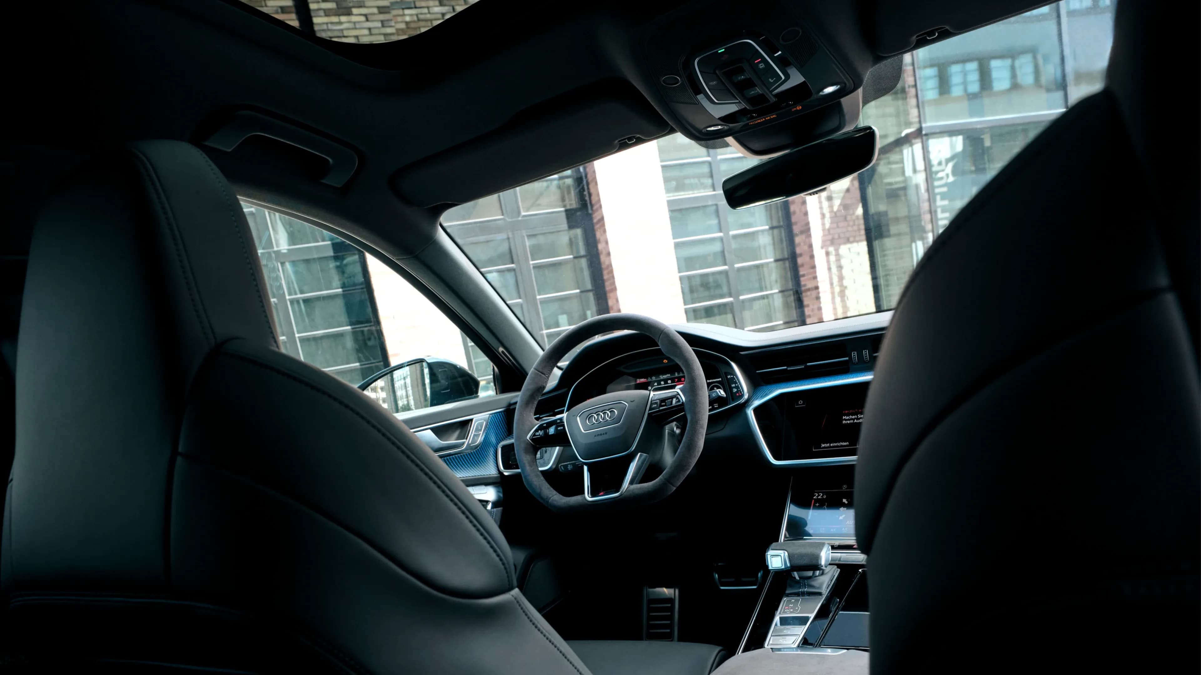 Interior rear view of an Audi RS6 Performance featuring an open panoramic roof and Alcantara steering wheel by Mosaik Motors.