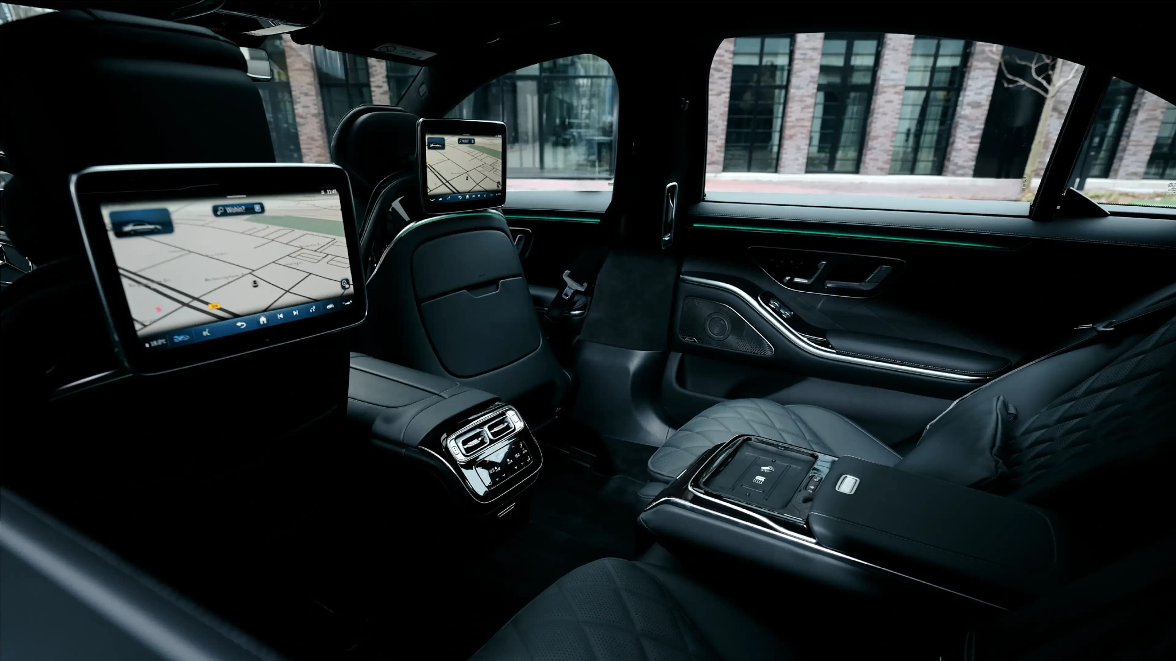 Mercedes-Benz S-Klasse mieten in München – Exklusiver Fondbereich mit zwei Bildschirmen an den Kopfstützen und edlen, gesteppten Ledersitzen von Mosaik Motors.