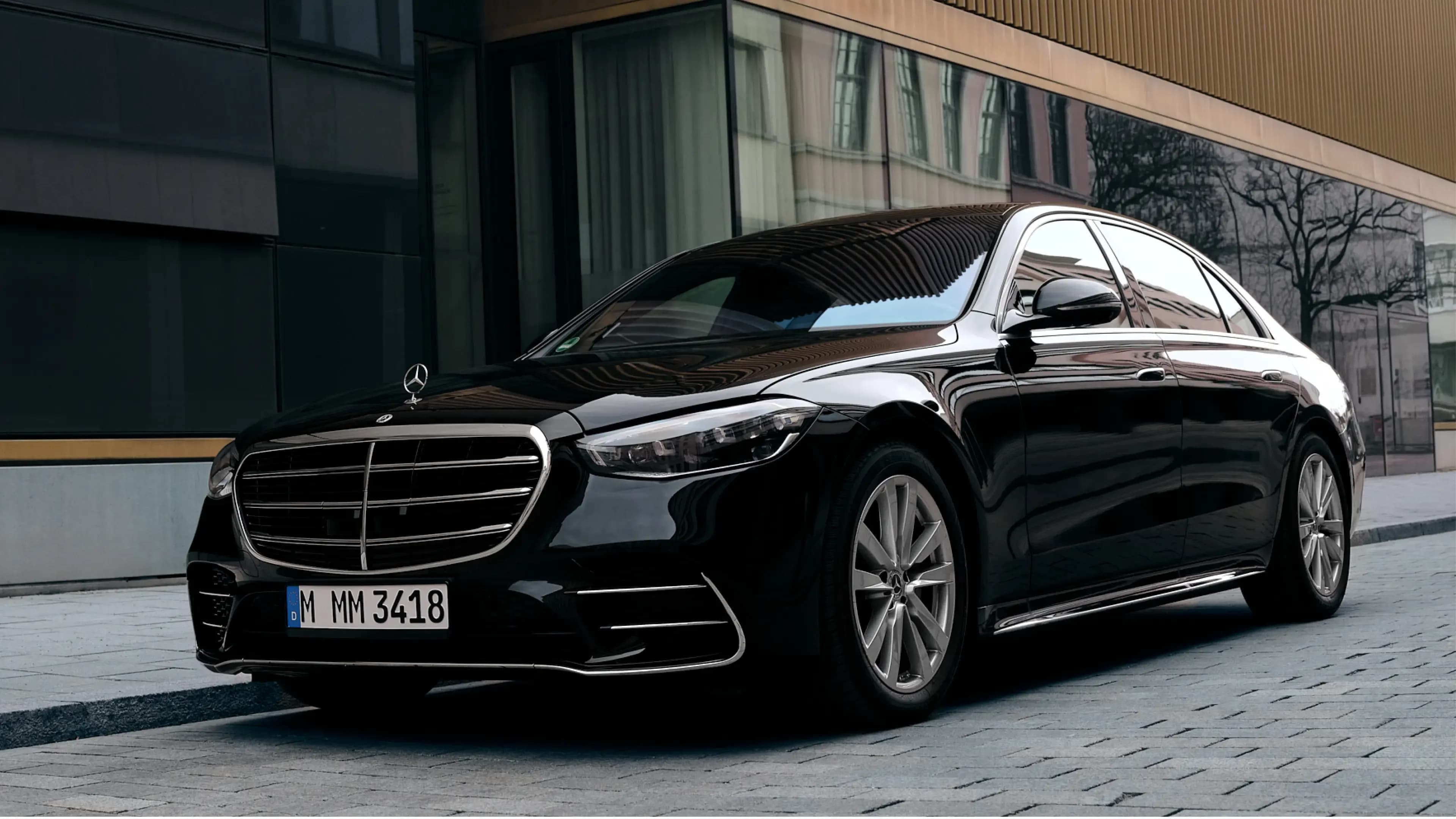 Schwarze Mercedes-Benz S-Klasse Limousine in der Dreiviertel-Frontansicht vor dem Lenbachhaus in München von Mosaik Motors.