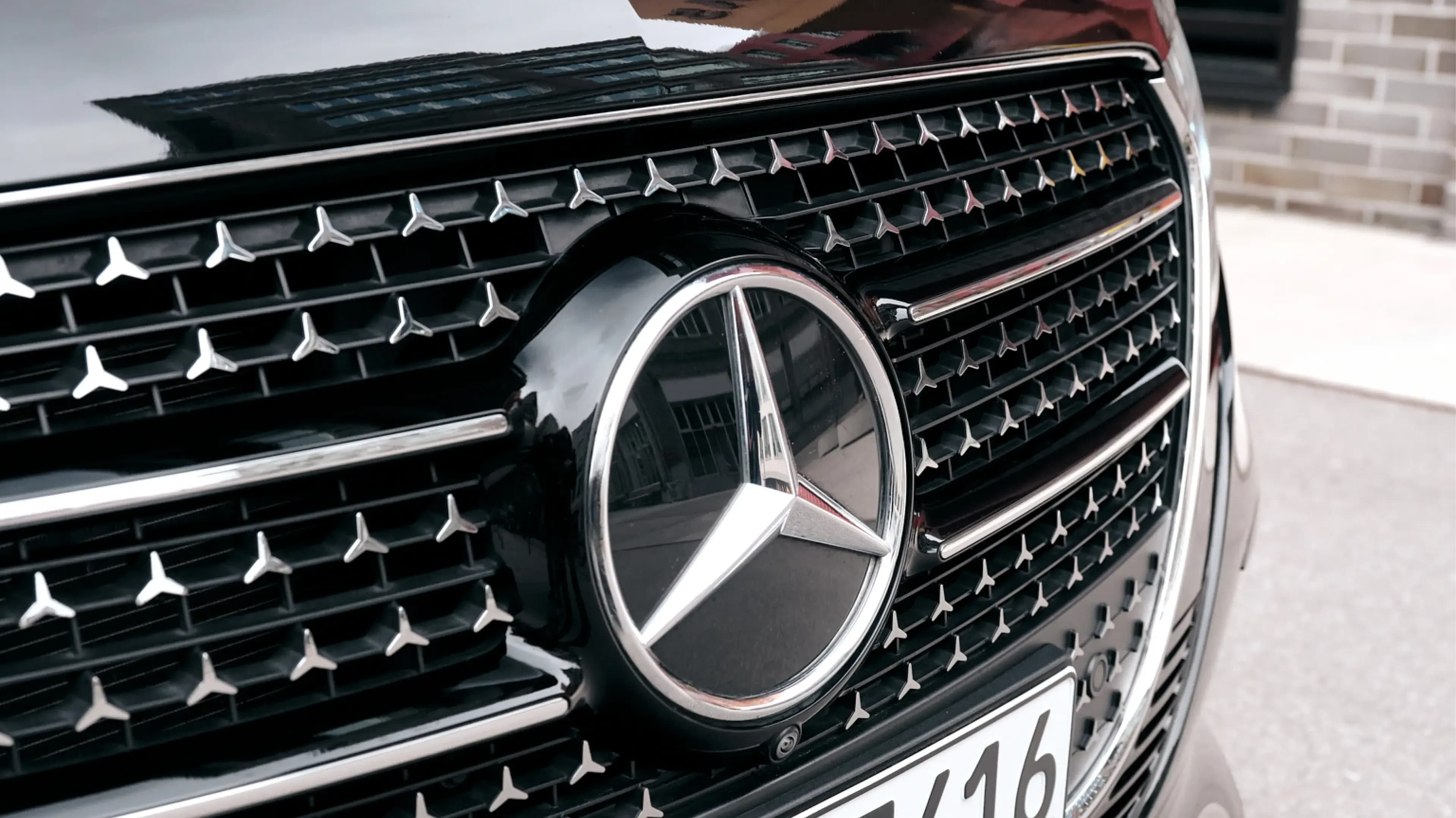 Mercedes-Benz V-Klasse mieten in München – Nahaufnahme des eleganten Kühlergrills mit Sternenmuster und zentralem Mercedes-Benz Markenlogo von Mosaik Motors.