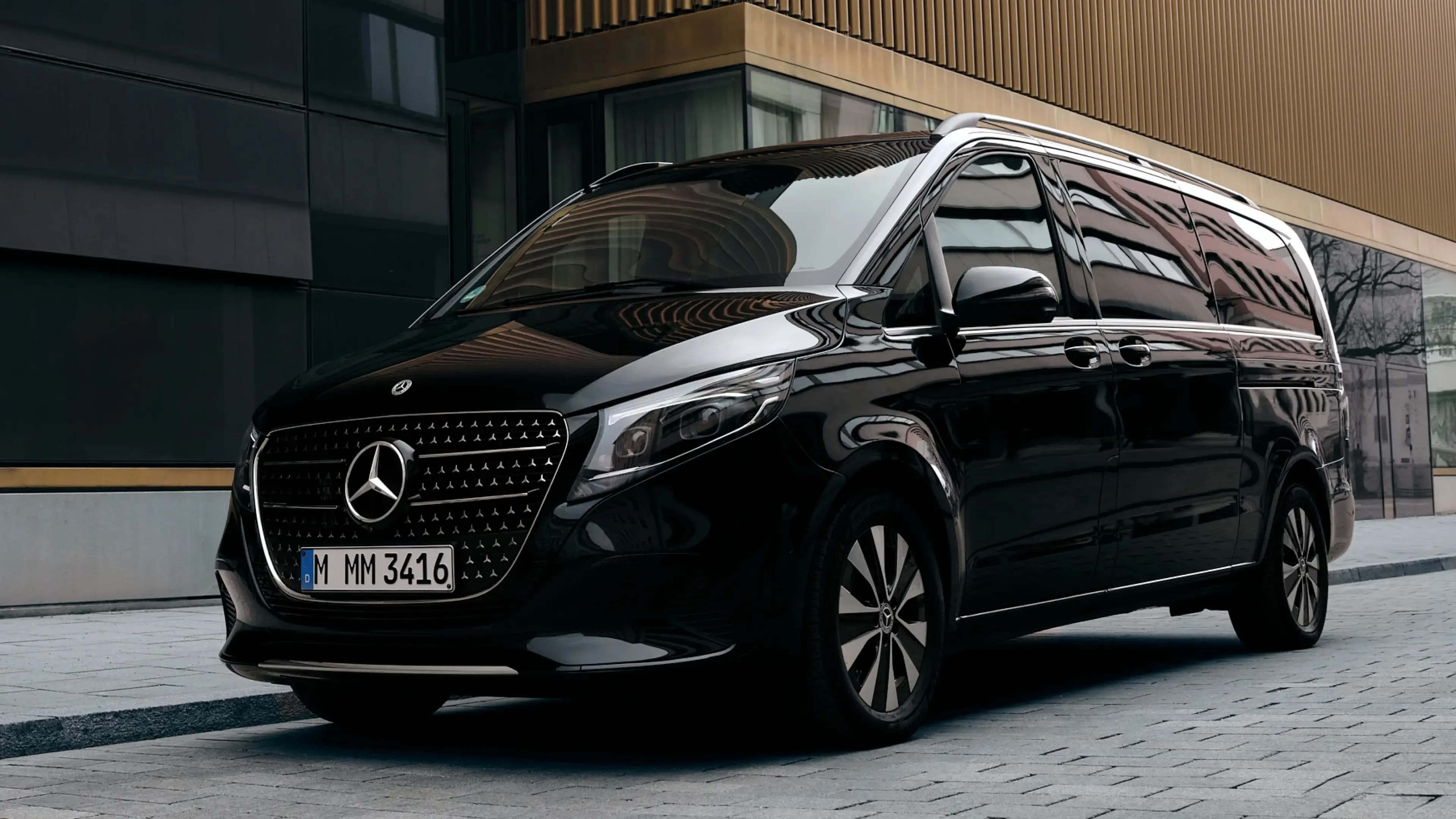 Schwarze Mercedes-Benz V-Klasse Großraumlimousine in der Dreiviertel-Frontansicht vor dem Lenbachhaus in München von Mosaik Motors.