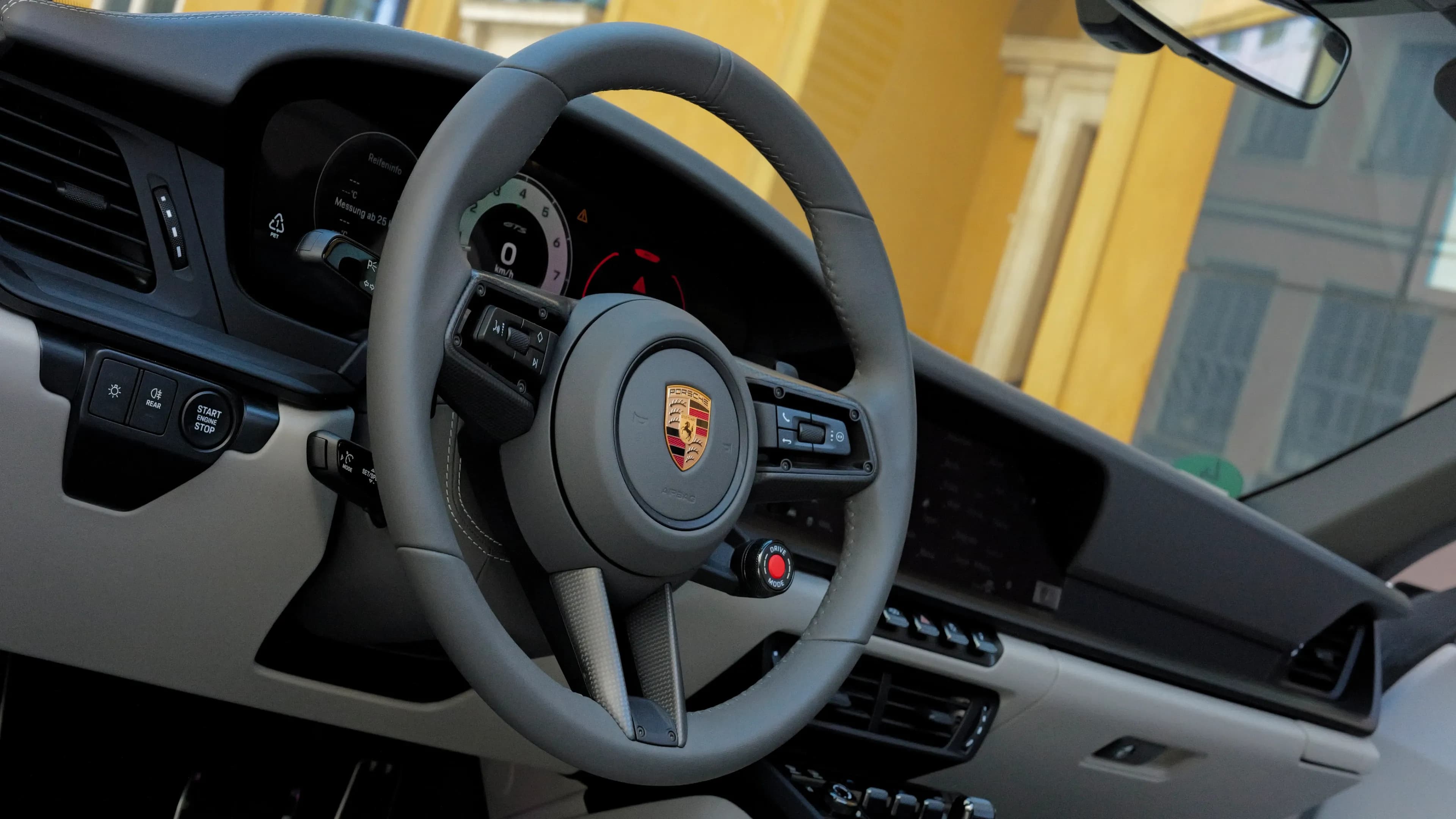 Sporty Alcantara steering wheel with the Porsche crest inside the cockpit of the Porsche Targa 4 GTS by Mosaik Motors Munich.