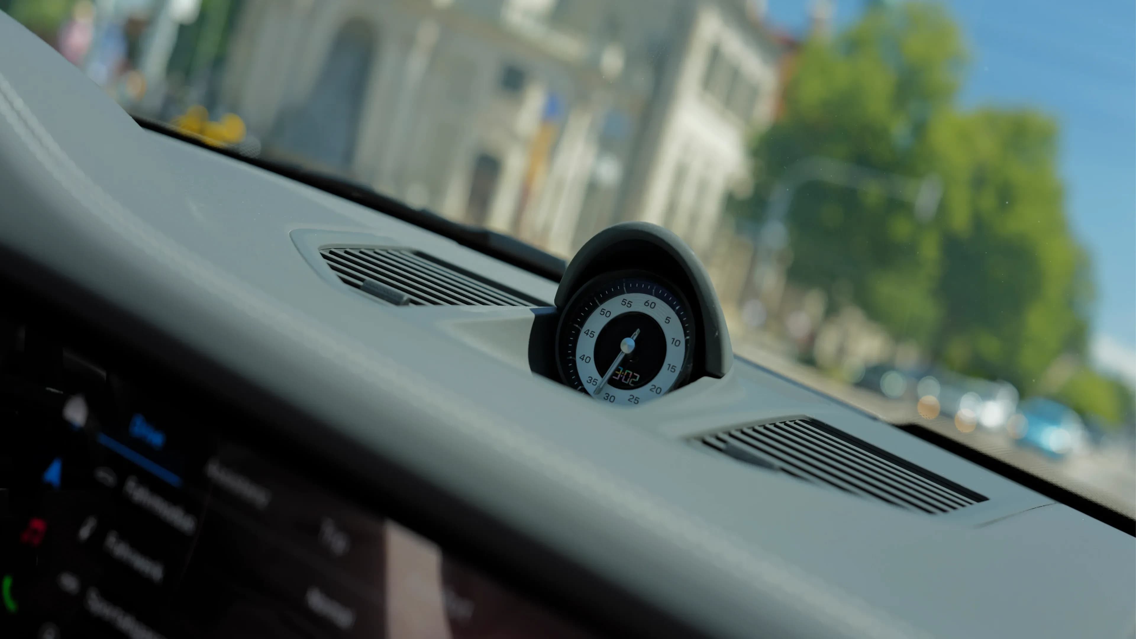 Close-up of the Porsche Sport Chrono clock on the leather dashboard of the Targa 4 GTS rental in Munich.