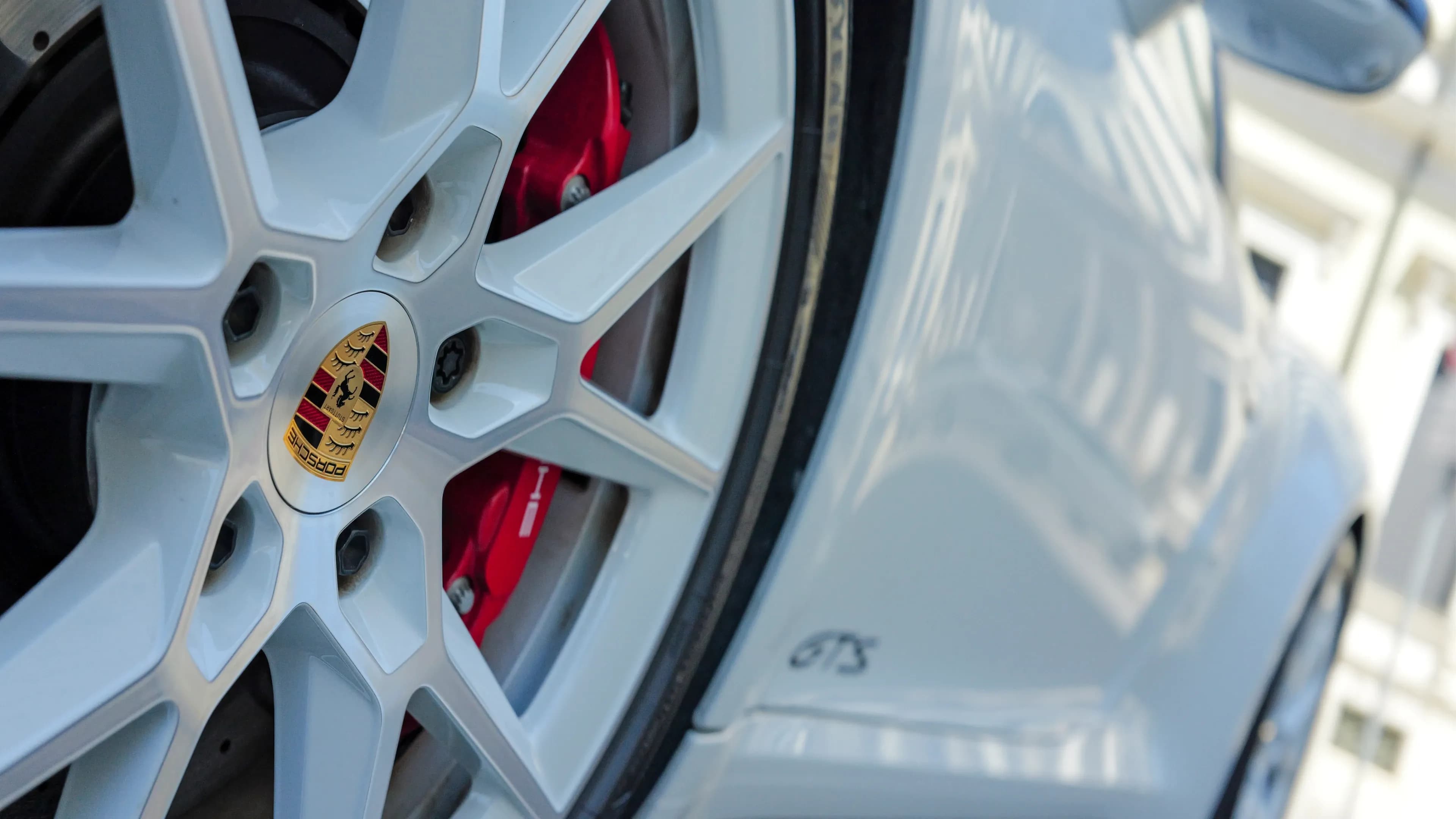 White Porsche Turbo S alloy wheels with center lock and red brake calipers on the Porsche 911 Targa 4 GTS in Munich.
